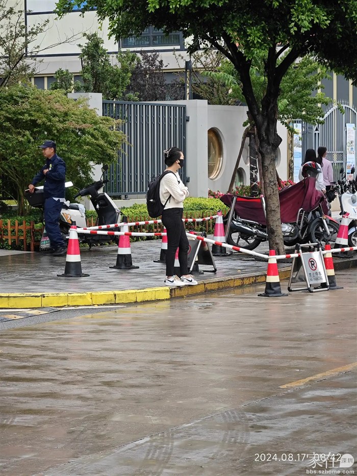 在小区门外等车的游人的穿着